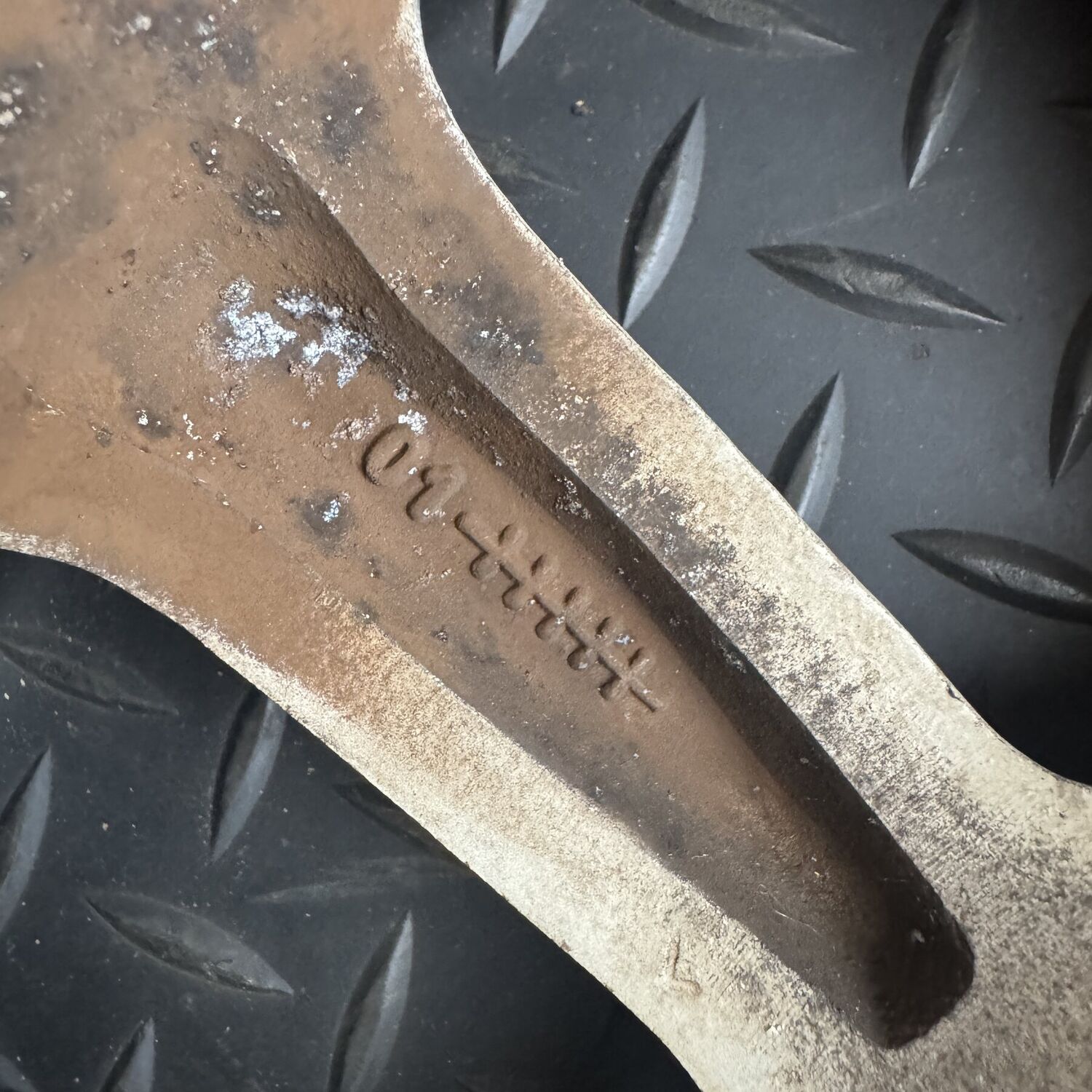 A two digit number followed by a row of cross marks cast into a spoke